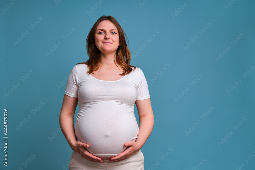 Happy smile on pregnant woman face, studio shot on blue background Happy smile on pregnant woman face, studio shot on blue background