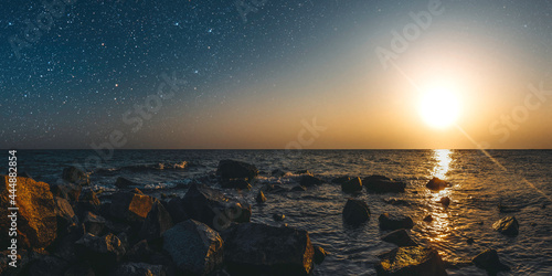 month on a background star sky reflected in the sea. © vovan