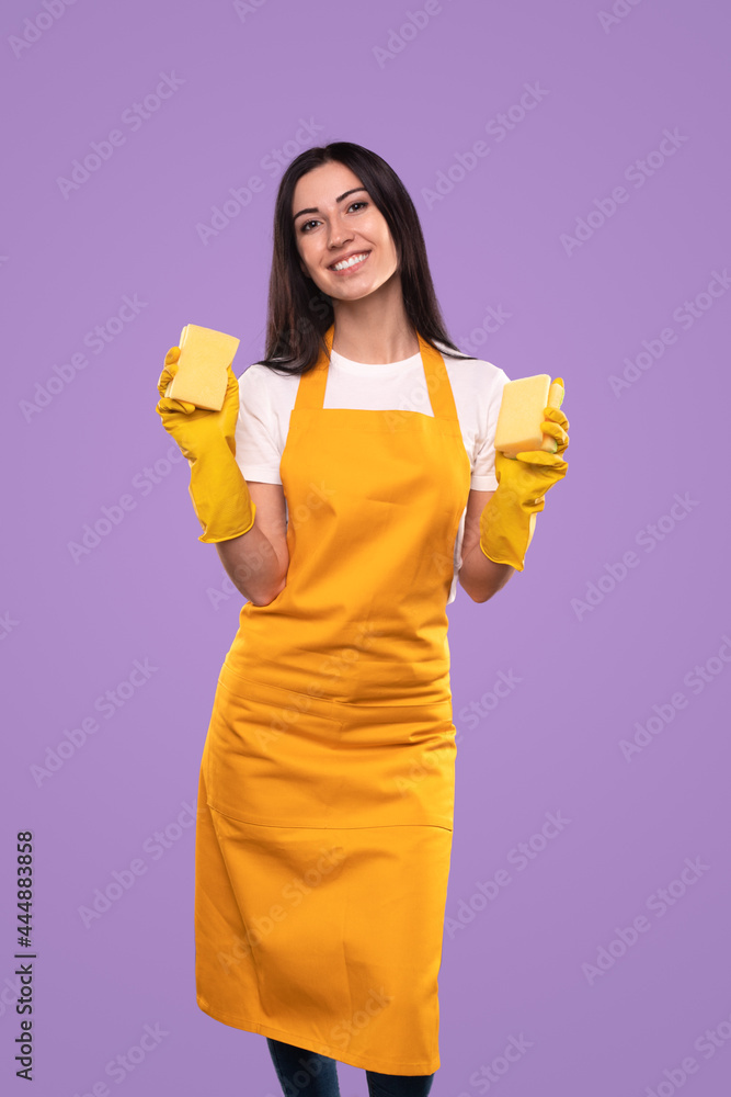 Smiling housewife with sponges ready for housework Smiling housewife with sponges ready for housework