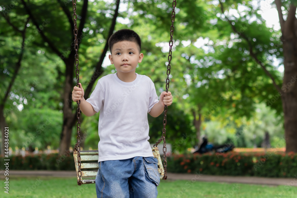 Cute Asian child on swing playing on outdoor playground. Cute Asian child on swing playing on outdoor playground.