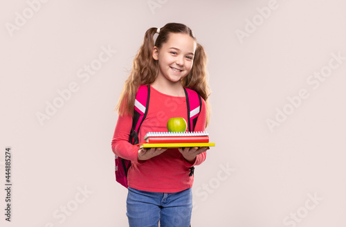 Happy schoolkid with copybooks and apple