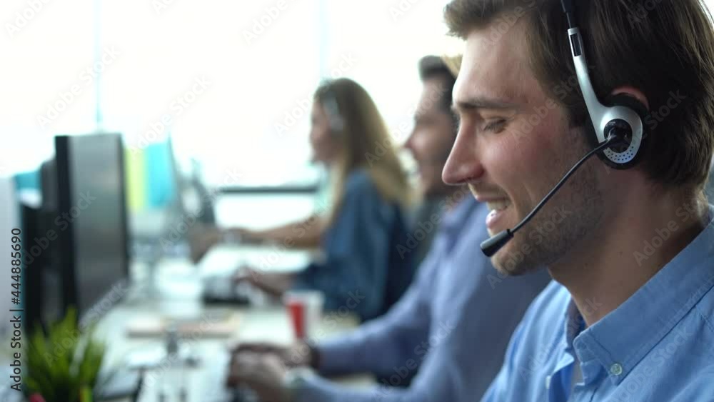 Male call center agent in headset helping client in customer support service