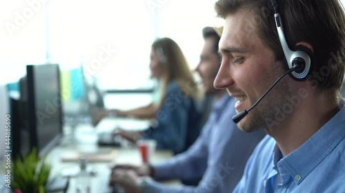 Male call center agent in headset helping client in customer support service