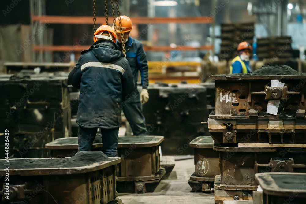 Unrecognizable workers with molds for metal cast in metallurgical plant foundry. Heavy industry. Unrecognizable workers with molds for metal cast in metallurgical plant foundry. Heavy industry.