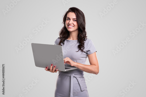 Smiling businesswoman with laptop looking at camera photo