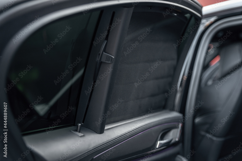 Car rear window side curtain. Sunblind curtain in a modern luxury car. Selective focus