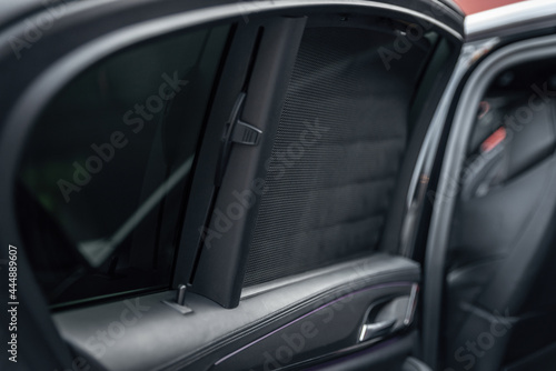 Car rear window side curtain. Sunblind curtain in a modern luxury car. Selective focus © Oleksandr