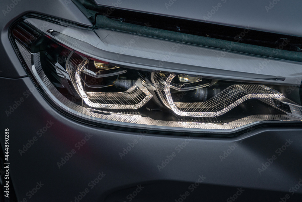 Fototapeta premium Close up part of automobile. The headlight of a modern luxury car from a close angle.