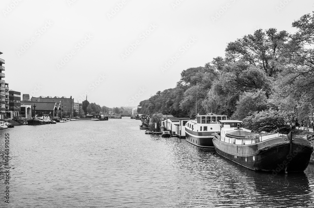 Naklejka premium AMSTERDAM, NETHERLANDS. JUNE 06, 2021. Beautiful view to a shipping channel and bridges. Black and white photography