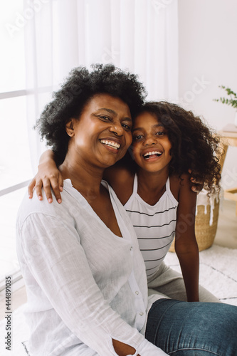 Smiling woman with granddaughter at home