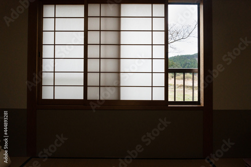 Traditional Japanese room with windows half open and tree branches outside. Photo taken in the village along the Kumano Kodo track in Japan.