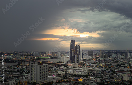 Bangkok, Thailand - 07 Jul 2021 : Aerial view of Beautiful sunset over large metropol city in Asia. There are prominent and isolated high-rise buildings along the Chao Phraya River. Selective focus.