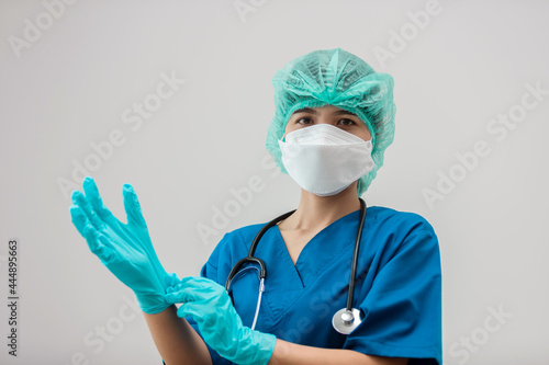 portrait view of a female doctor in uniform wearing surgical gloves preparing to operate, Medical staff working about protection coronavirus or covid-19, Medical concept