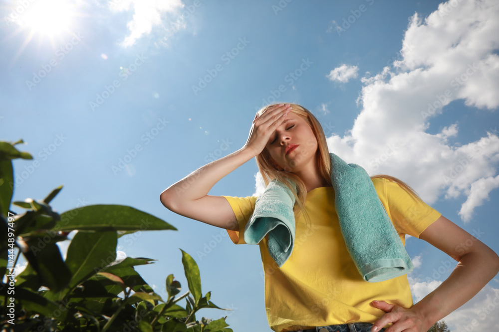 Woman with towel suffering from heat stroke outdoors Woman with towel suffering from heat stroke outdoors