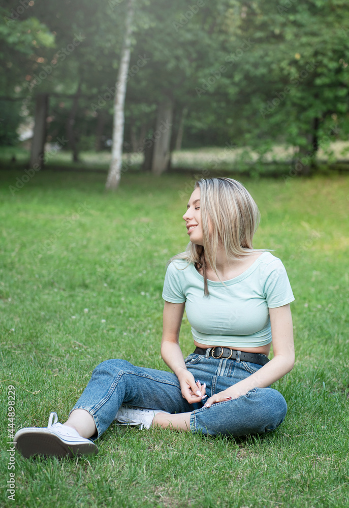 Photo of cute adorable woman sitting on fresh green grass Photo of cute adorable woman sitting on fresh green grass