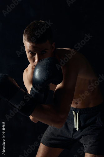 boxer in gloves on a black background bent down cropped © SHOTPRIME STUDIO