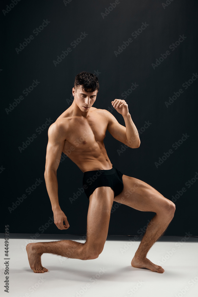 man with pumped up muscular body black panties posing dark studio background