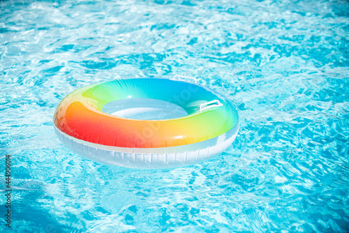 Inflatable ring in blue swimming pool. Colorful inflatable toy in swimming pool water  summer vacation background.