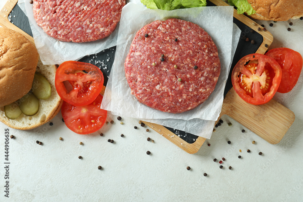 Concept of cooking burger on white textured table Concept of cooking burger on white textured table