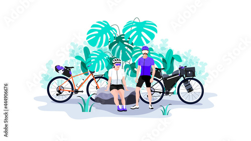 Young couple resting on nature during bike trip.