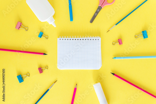 School supplies. Back to school. The concept of education. Everything for school and office. Pens, pencils, notepad, scissors and everything for studying on a yellow background. Flatly. Mock up.