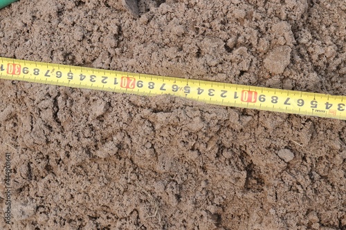 ruler on the ground, yellow tape measure measures the ground
