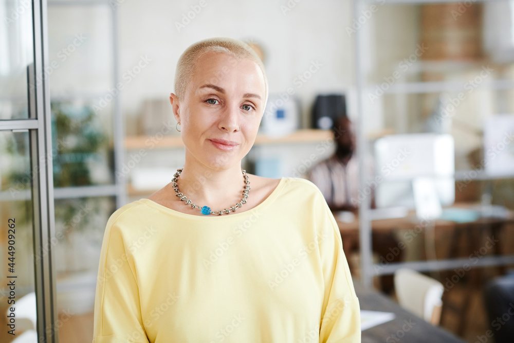 Portrait of mature business leader with short hair looking at caera while standing at office Portrait of mature business leader with short hair looking at caera while standing at office
