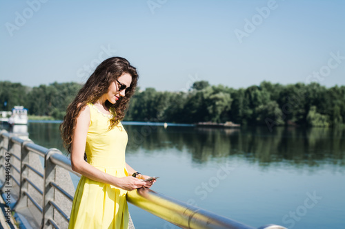 Beautiful girl in a yellow dress walks in a summer park © bisonov