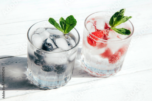 Glasses of strawberry and blueberry summer water. Cold fruit drinks. Summer refreshing healthy drinks for detoxification. Cocktails