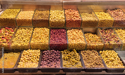 Different type of olives on the counter of a shop