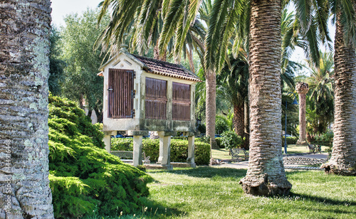 Tradicional hórreo gallego rodeado de palmeras en un parque del paseo marítimo de Cambados, España