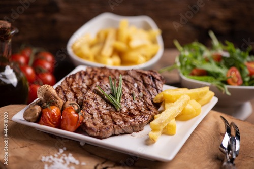 Sliced grilled medium rare beef steak served with fries