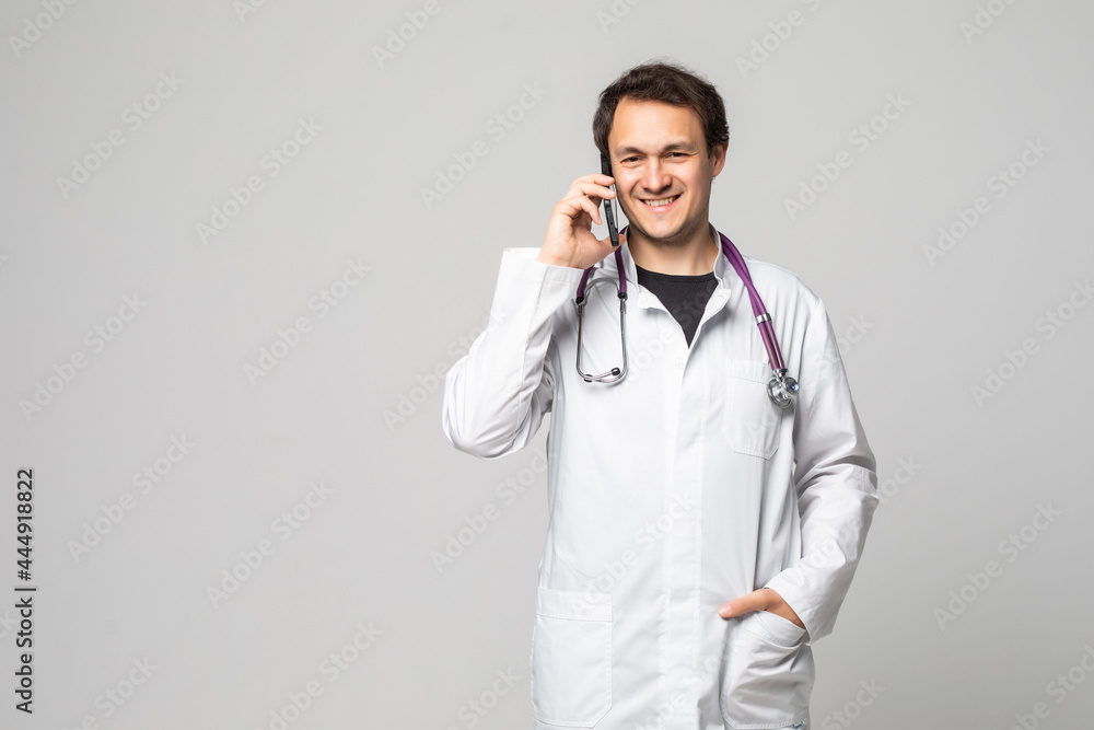 Portrait of successful doctor talking on phone. Smiling medical doctor with stethoscope talking on his cell phone, on white background. Concept of medical phone consultation. Portrait of successful doctor talking on phone. Smiling medical doctor with stethoscope talking on his cell phone, on white background. Concept of medical phone consultation.