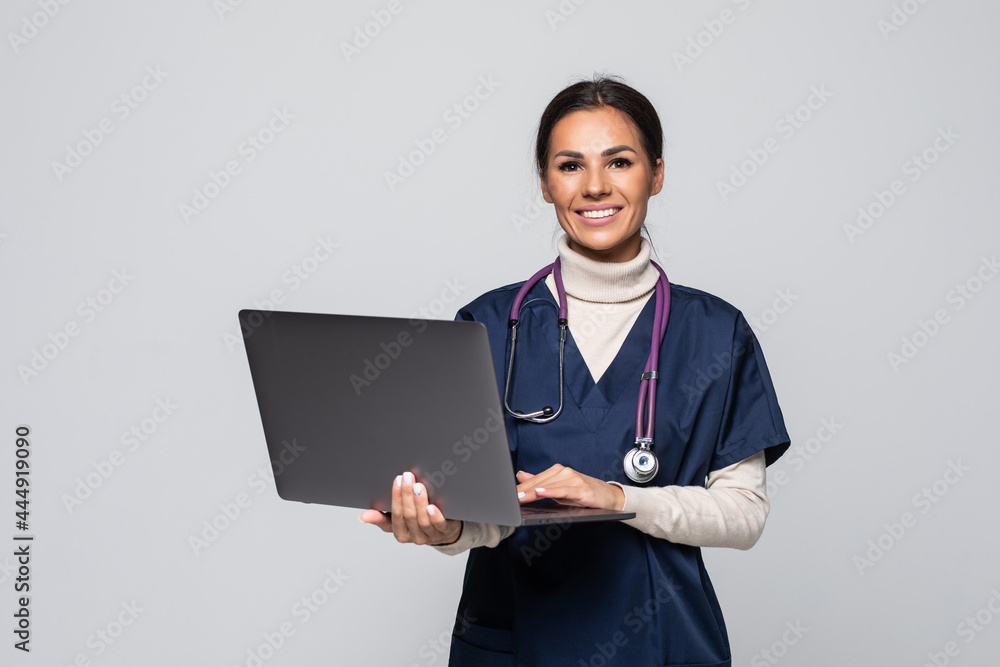 Beautiful woman doctor or nurse holding a laptop computer isolated on a white background Beautiful woman doctor or nurse holding a laptop computer isolated on a white background