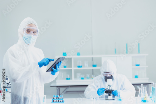 Two asian scientist team reserch chemistry science tube experiment biotech antibody sample in laboratory Cultivate Vaccine against covid-19 virus. Scientist consult  analyze in Chemistry Laboratory