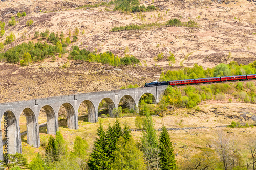 A close up view of a train approaching the viaduct at Glenfinnan, Scotland on a summers day