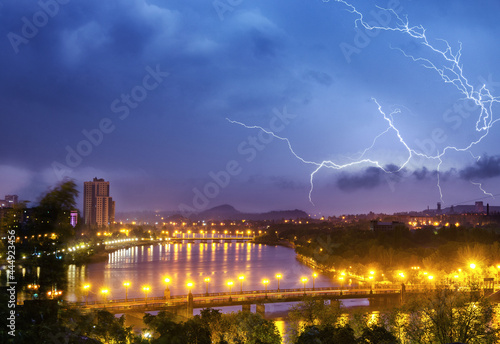 Thunderstorm with lightning over night city sky.
