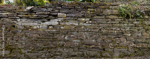 Eine alte römische Steinmauer ist wie ein Spiegelbild vieler vergangener Ereignisse und daher als ein stimmungsvolles Hintergrundbild wie geeignet