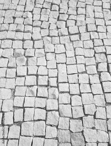 The road is made of square gray stone.
