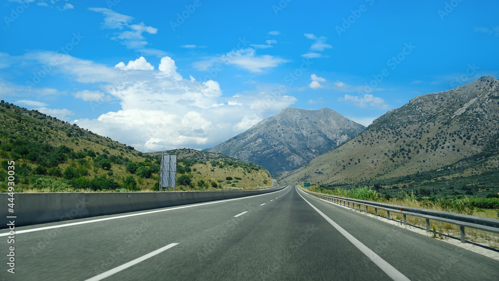 Driving car on a highway with view on scenic hills and mountains, European road.
