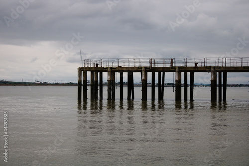 Part of old abandoned pier in the sea  Kent  England  Isle of Grain  on a cloudy day