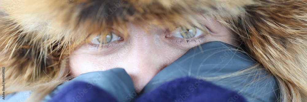 Fototapeta premium Woman in warm fur hat and mittens covering her face with hands