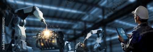 Engineer check and control welding robotics automatic arms machine in intelligent and  digital manufacturing operation on real time monitoring system software. Industrials 4.0 concept. Smart operation