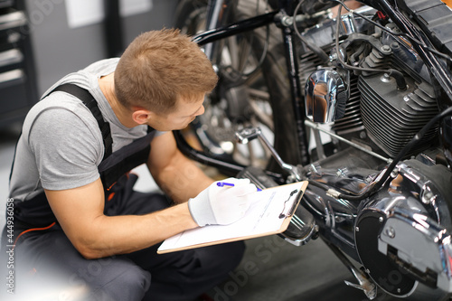 Obraz na płótnie Foreman in service repair center diagnoses parts on motorcycle w salonie