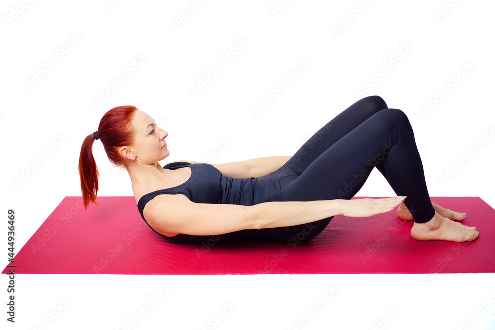A beautiful slender woman performs an exercise to develop the strength of the abdominal muscles on a gym mat. Diaphragm breathing. Isolated on a white background. A beautiful slender woman performs an exercise to develop the strength of the abdominal muscles on a gym mat. Diaphragm breathing. Isolated on a white background.