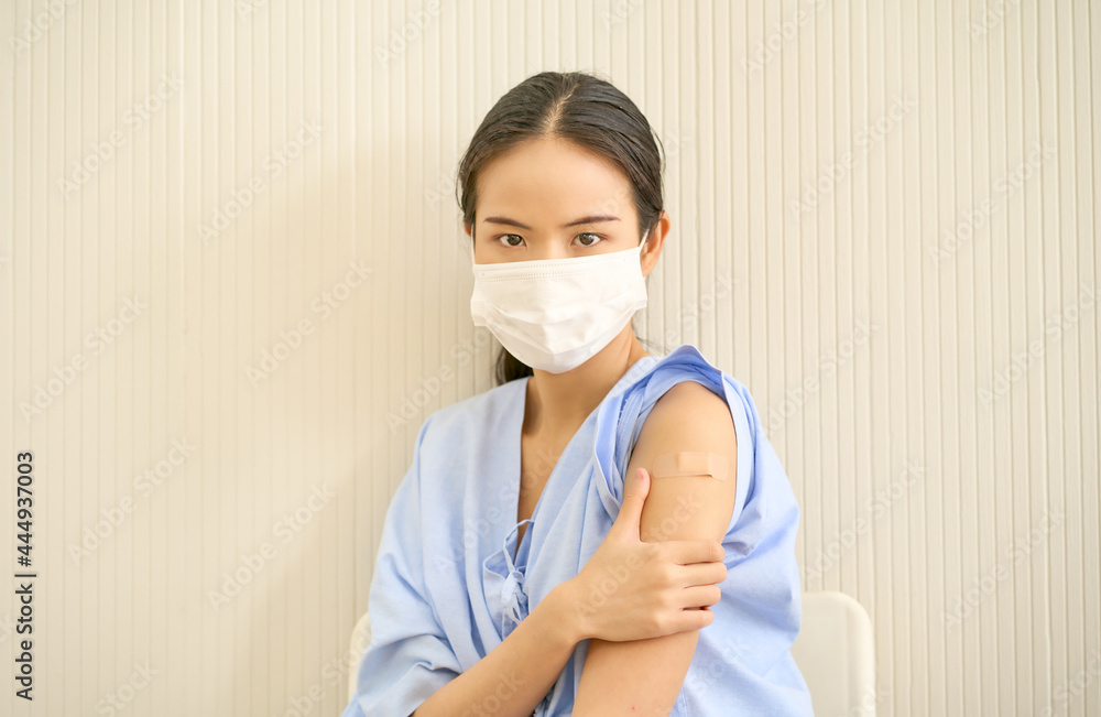 Asian patient female portrait after injected covid19 vaccine with plaster on her arm