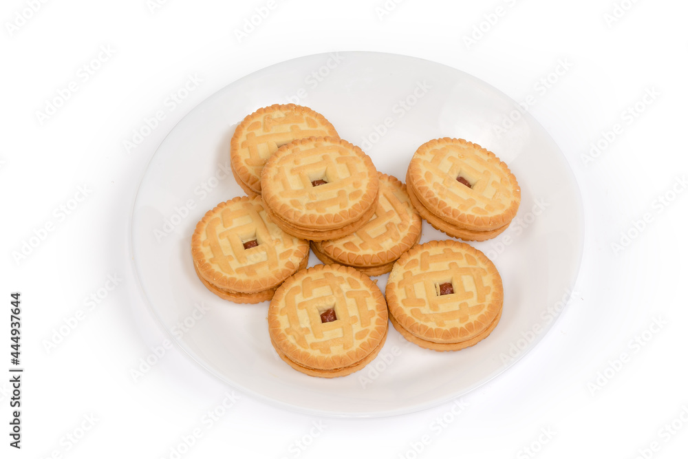 Round sandwich cookies with cherry jam filling on white dish