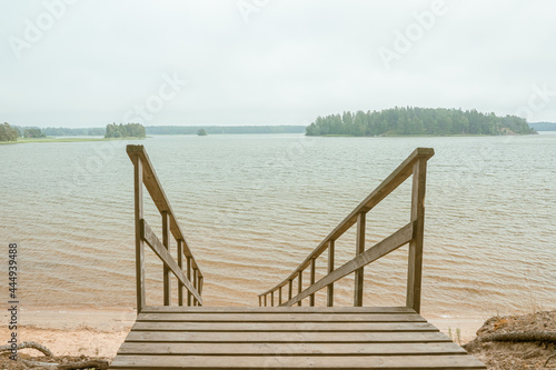 Wooden stairs to the seashore. Sandy beach, pine forest. Scandinavian nature. Finland. Porvoo photo