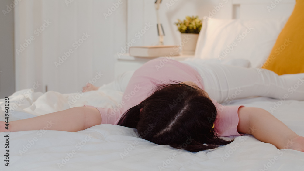 Young Asian girl play after wake up at home. Asia japanese woman child kid relax rest fun after sleep all night lying on bed, feel comfort and calm in bedroom at home in the morning concept. Young Asian girl play after wake up at home. Asia japanese woman child kid relax rest fun after sleep all night lying on bed, feel comfort and calm in bedroom at home in the morning concept.