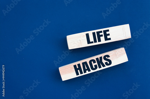 Wooden block with words LIFE HACKS on the blue background